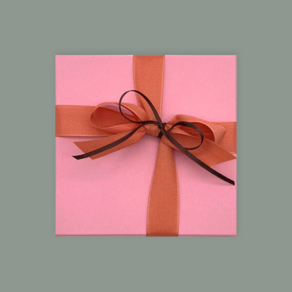 Rosa Pralinenbox für 12 Pralinen in quadratischer Form. Mit rosa Schleife und kleiner braunen Schleife.