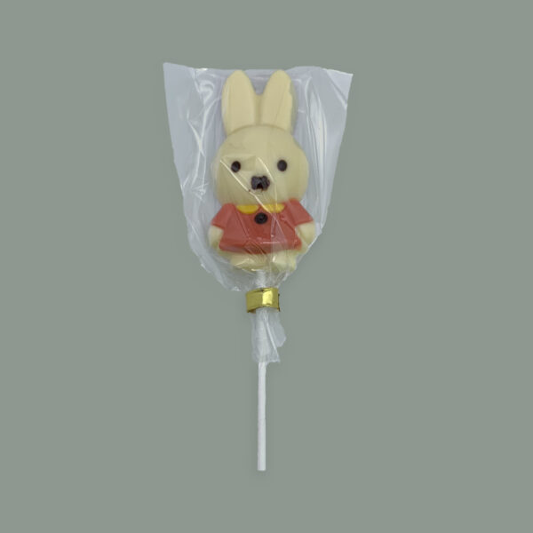 Lolly aus weißer Schokolade in Mini Miffy (Osterhasen Form). Verziert mit gefärbter weißer Schokolade. Verpackt in durchsichtigem Tütchen.