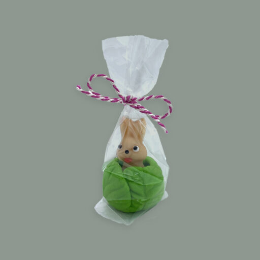 Kleiner Hase in Kohlkopf. Alles aus Marzipan. Verpackt in durchsichtigem Tütchen mit bunter Schleife.