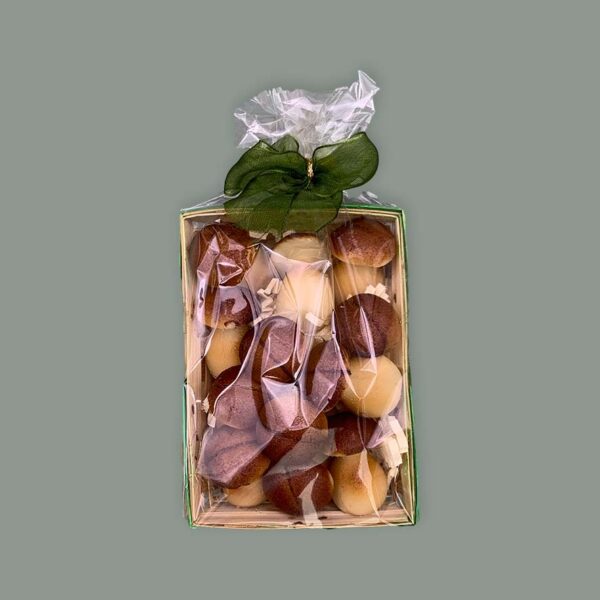 Körbchen gefüllt mit Spänen und kleinen Pilzen aus Marzipan. Verpackt in durchsichtigem Tütchen mit Schleife