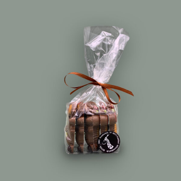 Vollmilchschokolade in Form von Igeln, verziert mit weißer Schokolade verpackt in durchsichtiger Tüte mit Schleife